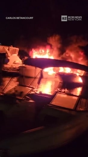 Several boats caught fire at Marina 59 in Far Rockaway, Queens, located on Beach 59th Street in Arverne early Wednesday morning. Video footage captured the dramatic scene, showing multiple vessels engulfed in flames and thick black smoke rising into the sky. Two people received medical attention at the scene and one firefighter was taken to St. John’s Hospital. The cause of the fire is still under investigation. | CBS New York
