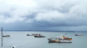 Time lapse of local boats lying at anchor off the coast with a strong current near the boat moorings and storm clouds gathering in the