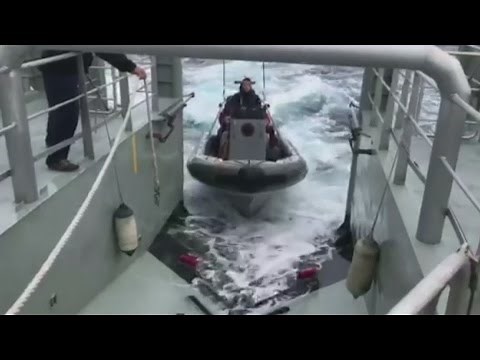 Sailing couple rescued from capsized yacht in heavy seas