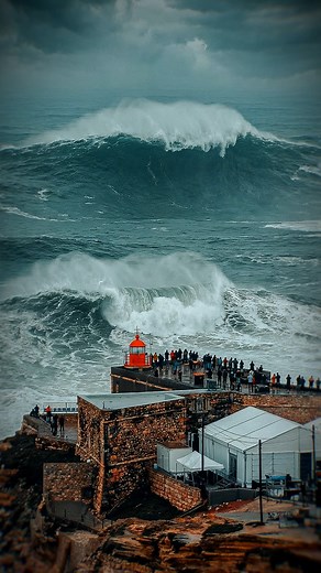 The lighthouse watches. The crowd waits. And then, the giant wave rises with precision and absolute power. Nazaré at its highest level... 🌊🔥 #bigwaves #nazareportugal #bigwavesnazare #powerofnature #nazare #waves | Big Waves Nazaré