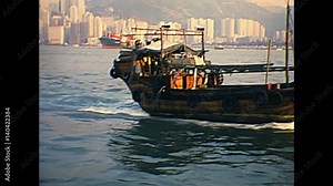 airplane taking off in Hong Kong skyline, Victoria Harbour with Sampan fishing boat. Historic restored archival footage on 1980s.
