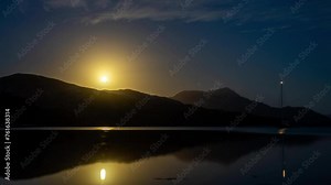 time lapse of a yacht and boat under clouds over mountains over the water in a national park and beautiful rock mountain above the ocean in a national park