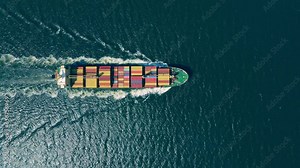 Aerial view of large container ship cruising in open sea, top down view